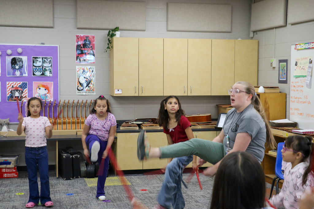 A teacher demonstrates a musical dance.