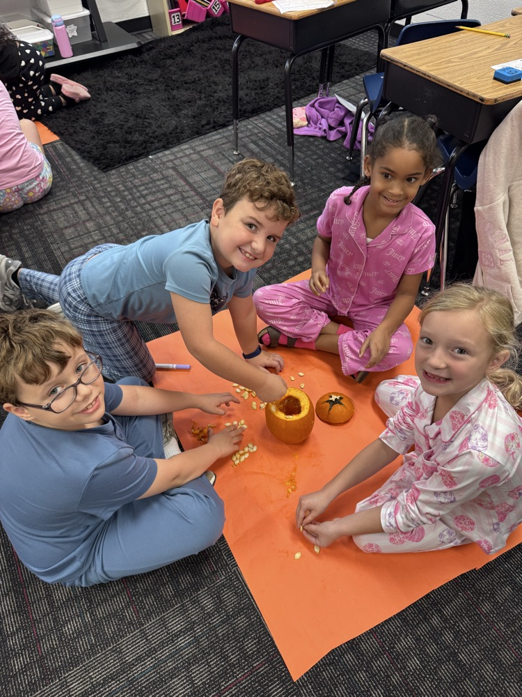 Students sitting on the floor with pumpkin seeds 