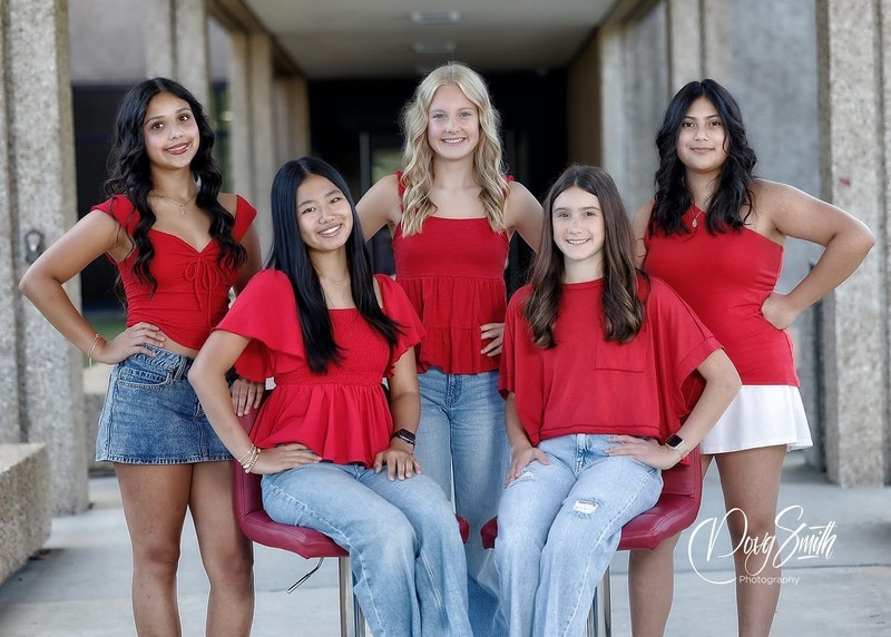 a group of girls smile in their red shirts