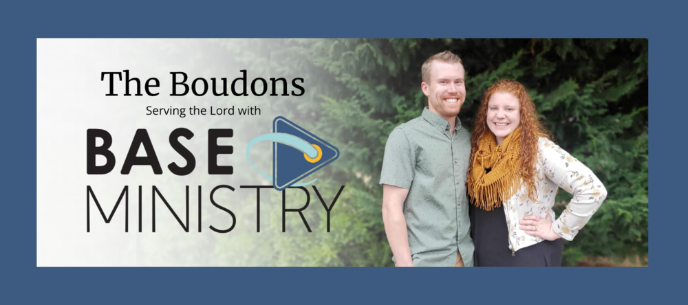 man and woman standing in front of evergreen trees