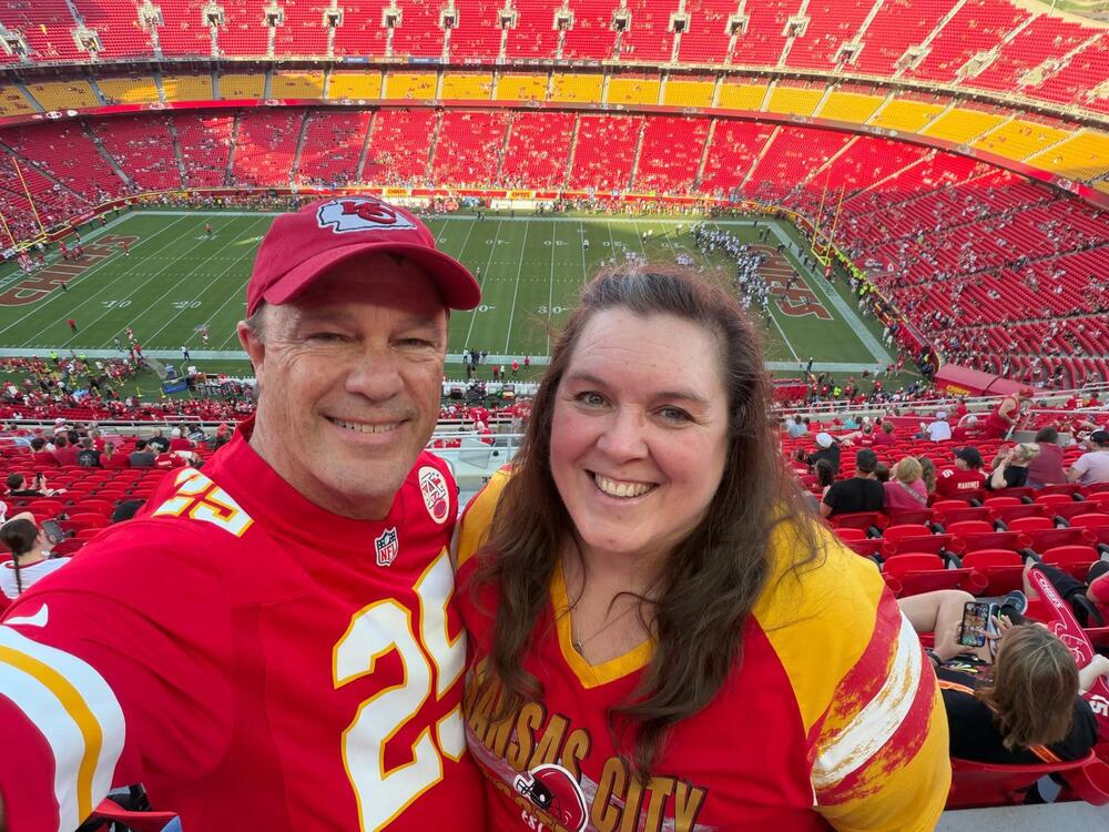 man and woman in football jerseys smiling at the camera