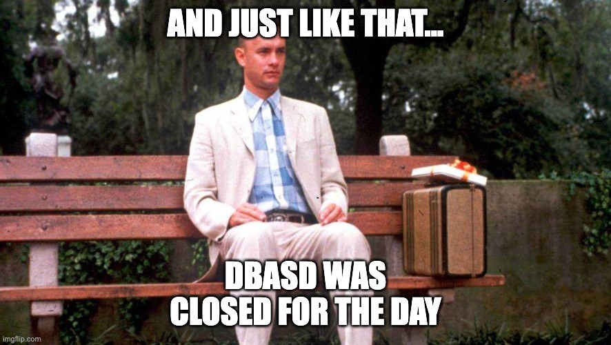 A still image from Forrest Gump showing Forrest sitting on a park bench with a suitcase beside him. White text at the top reads, βAND JUST LIKE THATβ¦β and text at the bottom reads, βDBASD WAS CLOSED FOR THE DAY.β