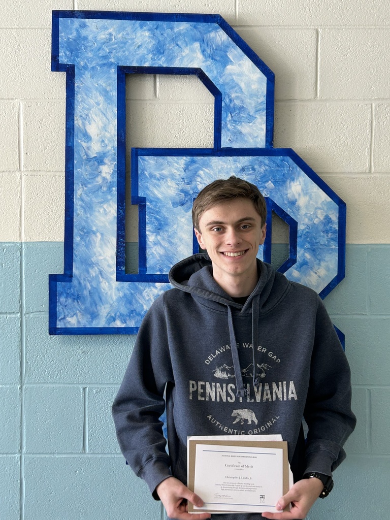 National Merit Scholarship Finalist Christopher Landis standing with his certificate in front of a DB logo