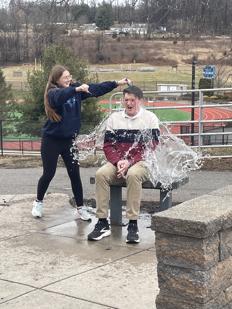 Student popping a water balloon over Mr. Puleo's head.