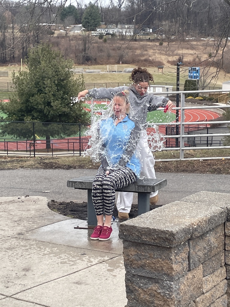 Student popping a water balloon over Mrs. Werner's head.