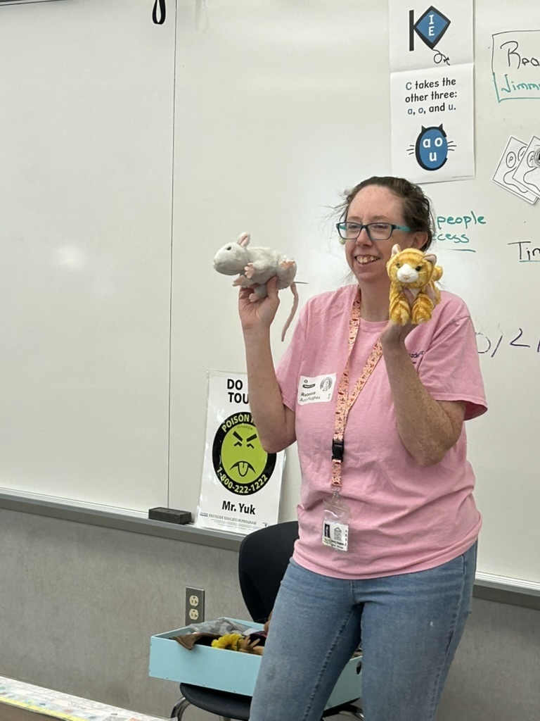 Penn State Master Gardener talking to students with a stuffed mouse and  tiger Mr. Yuck sticker in background.