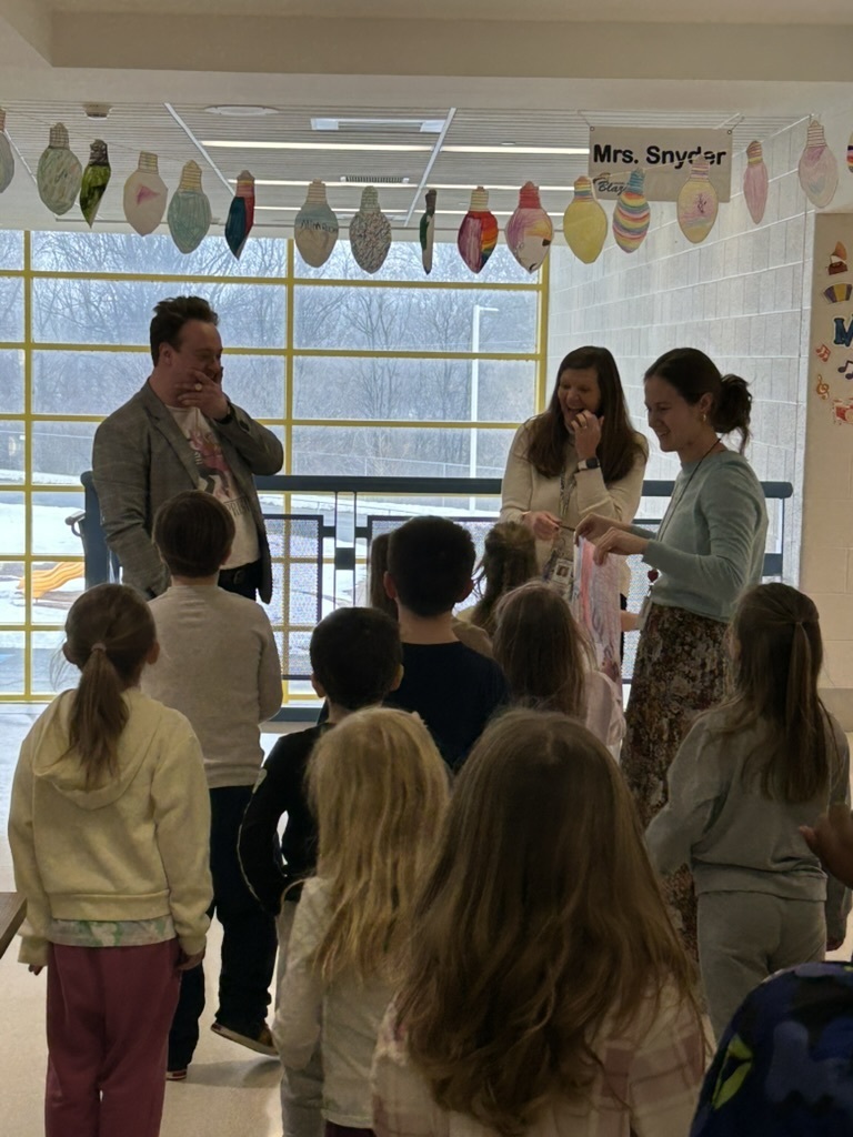 Miss Goudie's class surprising Mr. Steinman with a hand colored picture of him.