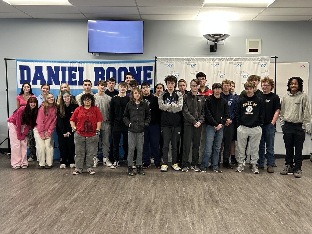 Accepted student photo in front of Daniel Boone and BCTC step and repeat banners.