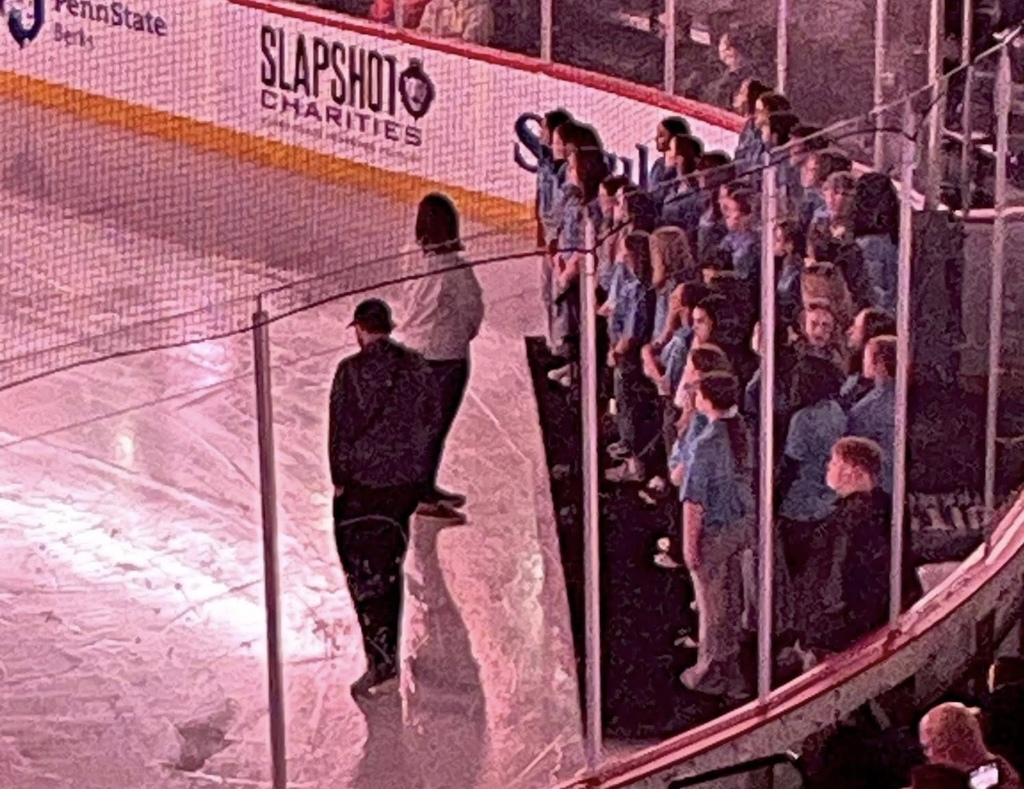 DBAMS Select Chorus on risers next to the ice rink ready to perform.
