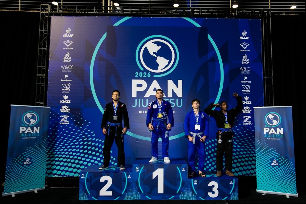 PAN Jiu-Jitsu backdrop with four winners standing on the podium recognizing first, second and two third place winners.