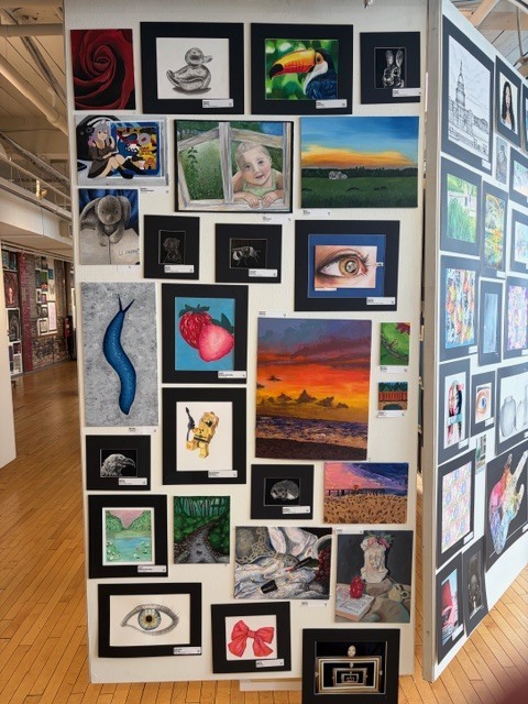 Student drawings displayed on large panels at the Goggleworks