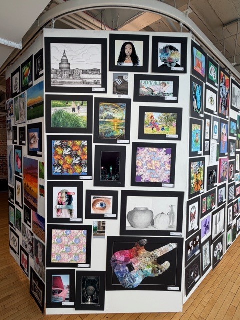 Student drawings displayed on large panels at the Goggleworks