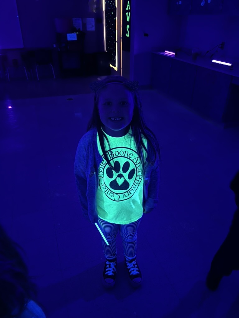 Picture of a student whose Daniel Boone Area Primary Center t-shirt glows yellow under blacklight