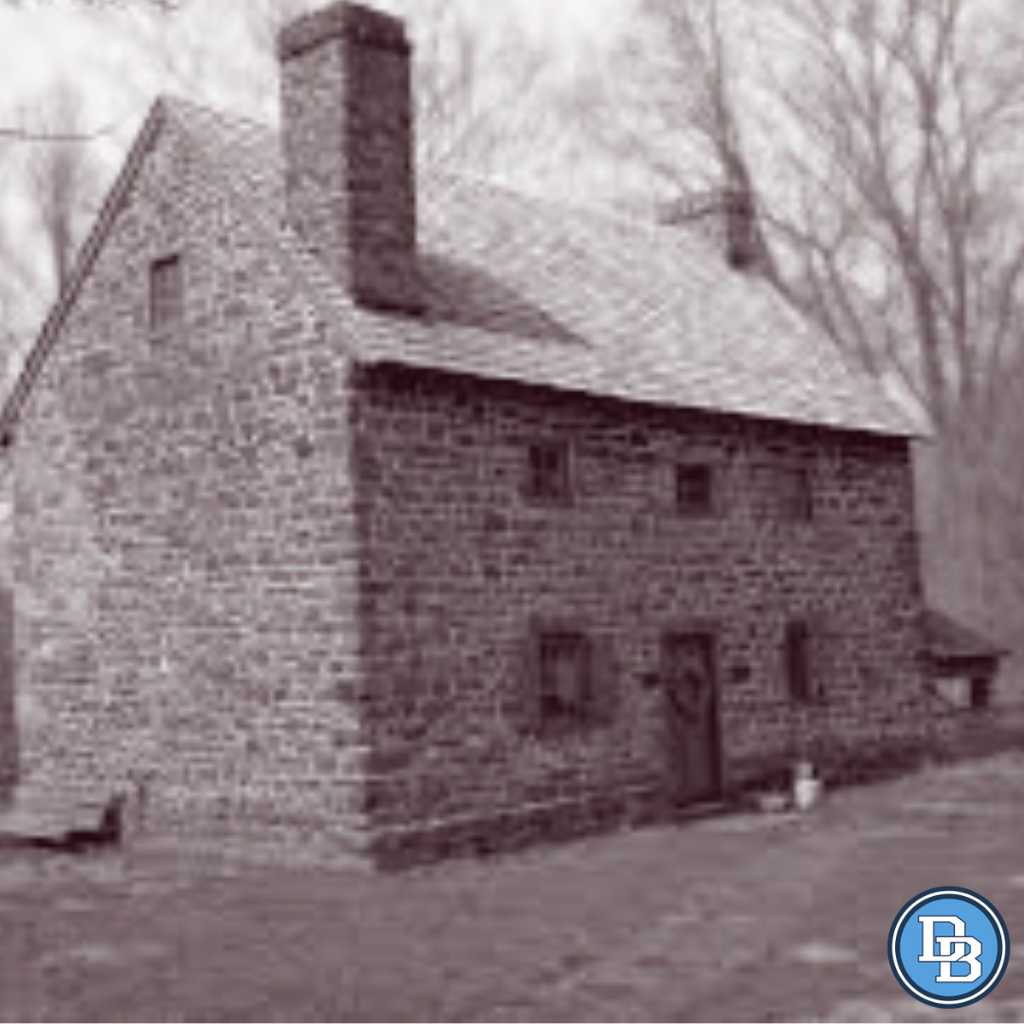 Original black and white photo of the Mouns Jones House in Douglassville. It's a stone house with five windows and a door on the front of the buidling.