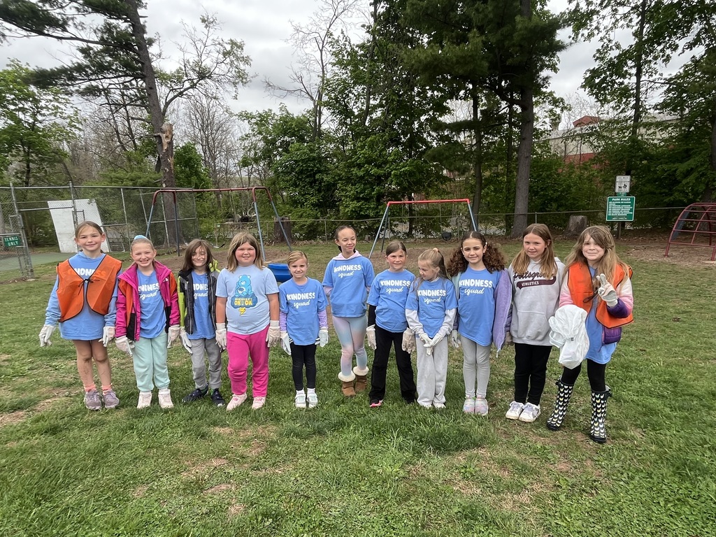 11 Kindness Squad students posing for a picture at Vest Pocket Park with swings in the background