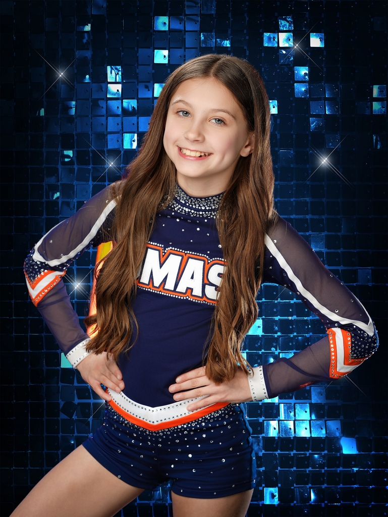Professional photo of student wearing navy and orange sparkly cheer outfit for UMAS.