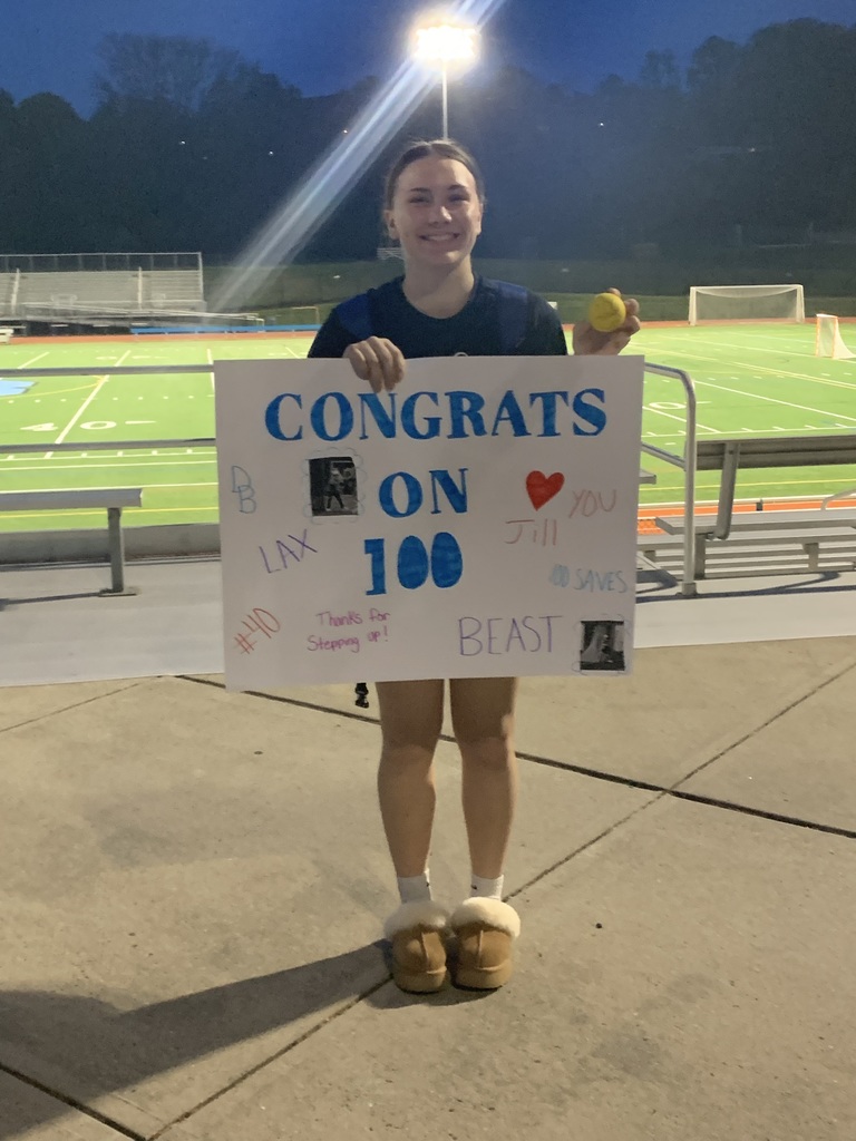 Image of student standing in the stadium holding a ball and a sign that says Congrats on 100 LAX #40 DB Beast 100 Saves
