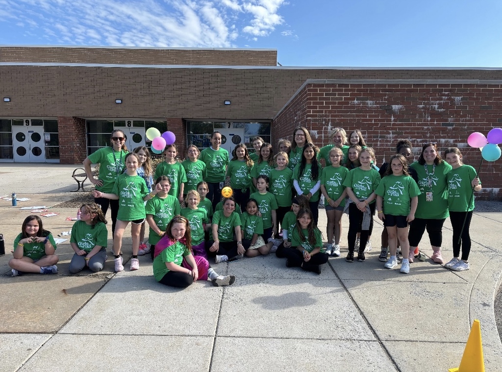 Picture of 35 staff and students wearing Green Girls on the Run T-shirts standing outside on the sidewalk of the Intermediate Center