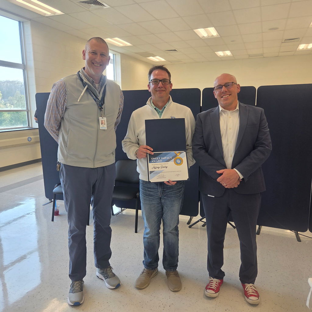 Aaron Sborz, Jeff Bailey and Tom Voelker are standing in the Daniel Boone Board Room smiling for the camera while Jeff Bailey holds his Sweet Impact Award Certificate.