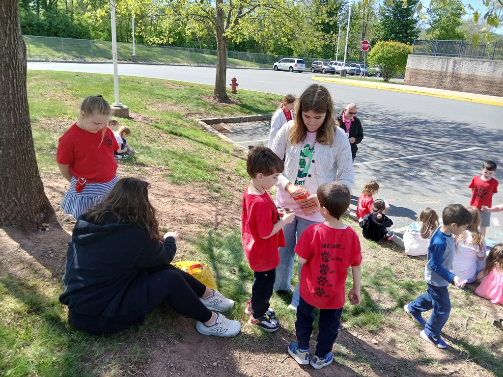 Three students with two helpers getting instructions on planting.