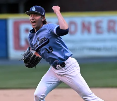 Photo of Greyson Bell on the pitching mound wearing his #19 Daniel Boone baseball uniform with his fist up in the air in celebration.