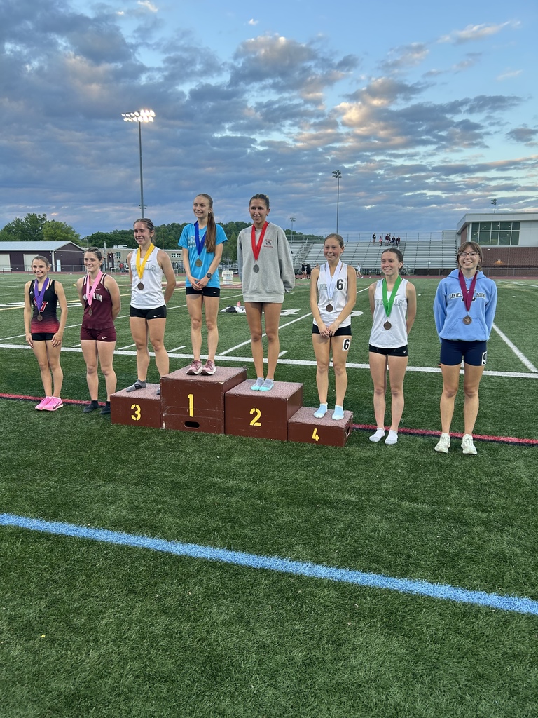 Eight students standing on the football field wearing medals.