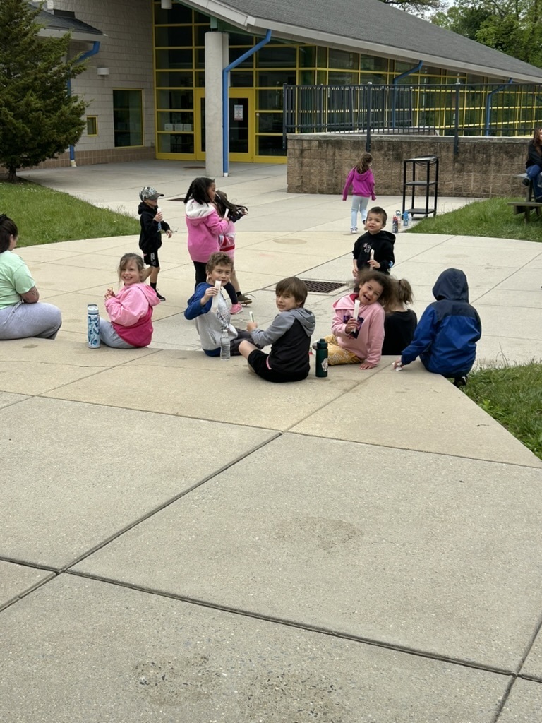A picture of 11 students enjoying freeze pops on the playground.