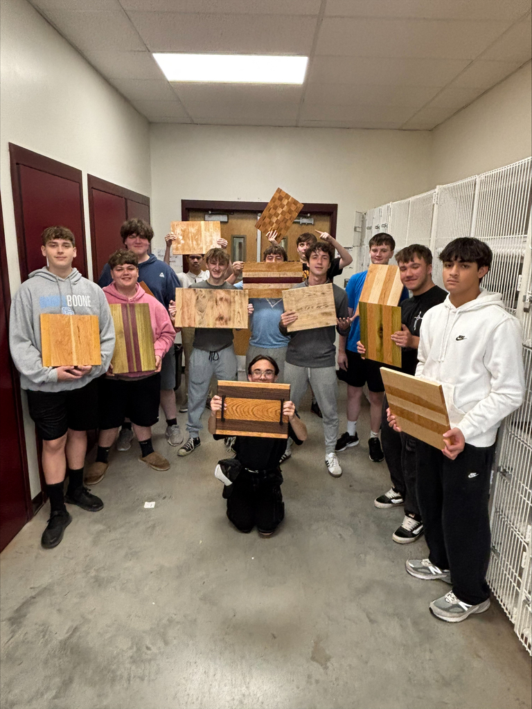 Group of 12 students each holding their finished serving board.