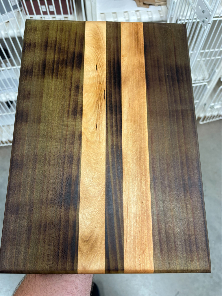 Dark finish serving board with two lighter finished striped pieces in center.