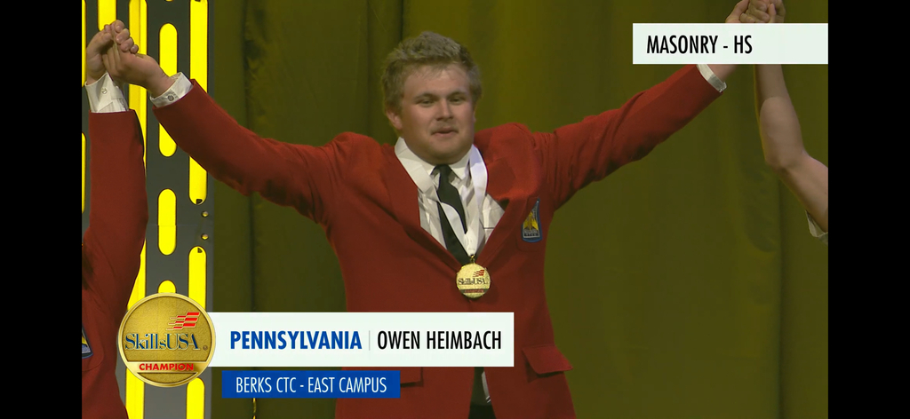 Screenshot picture of Owen Heimbach wearing a red blazer, black tie with white shirt and a first place medal around his neck. Captions read Masonry - HS, Skills USA Championship - Pennsylvania Owen Heimbach Berks CTC - East Campus