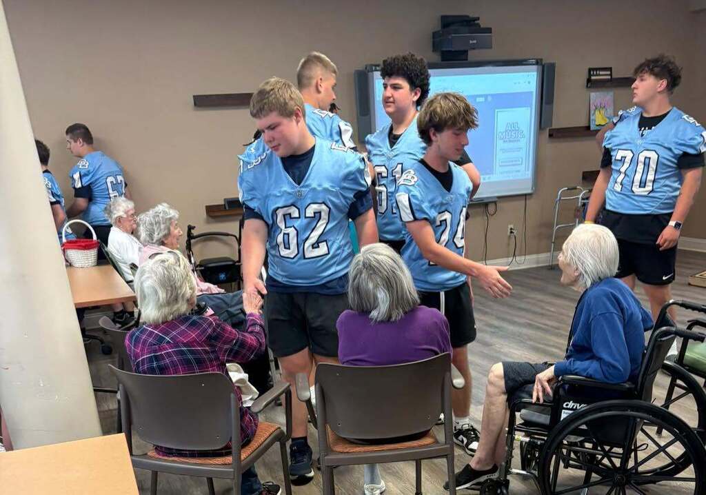 Members of the Boone football team shaking hands with residents of Keystone Villas