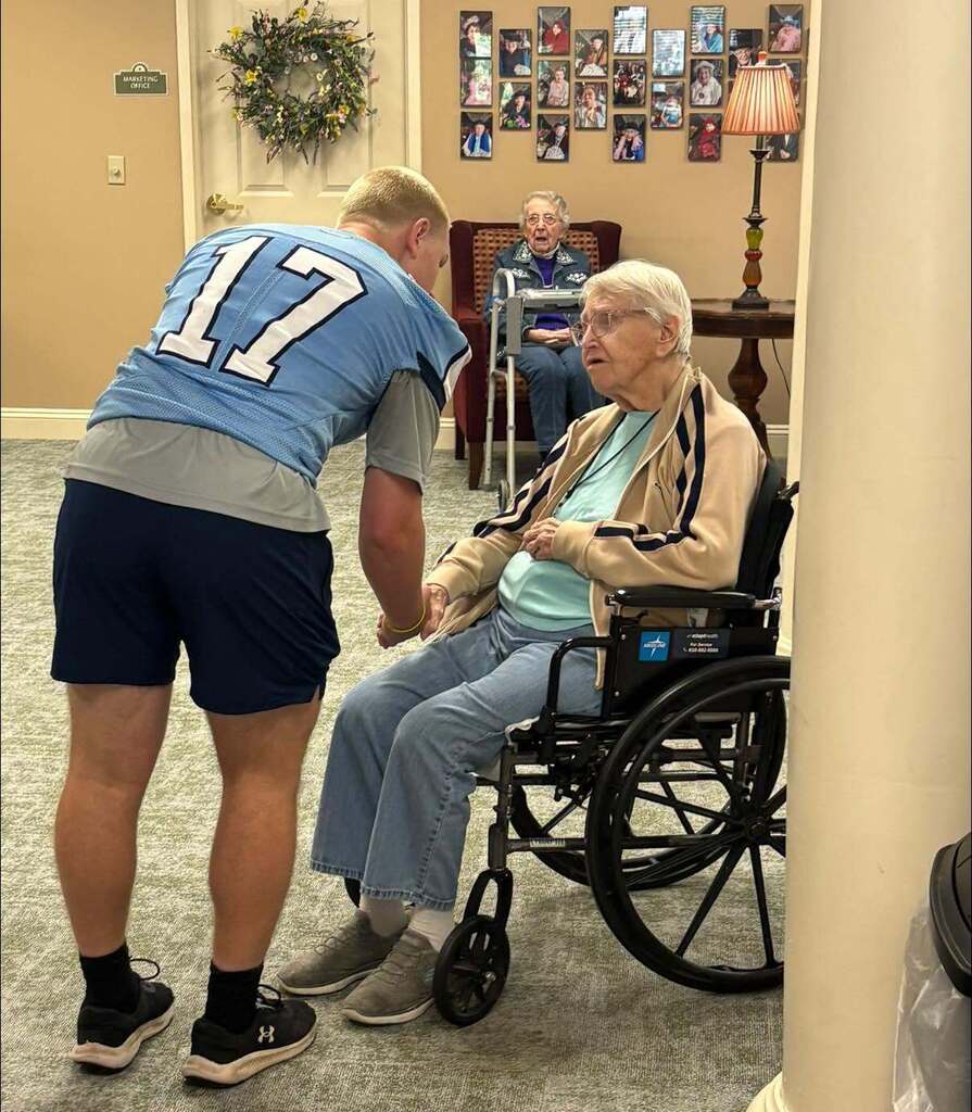 Members of the Boone football team shaking hands with residents of Keystone Villas