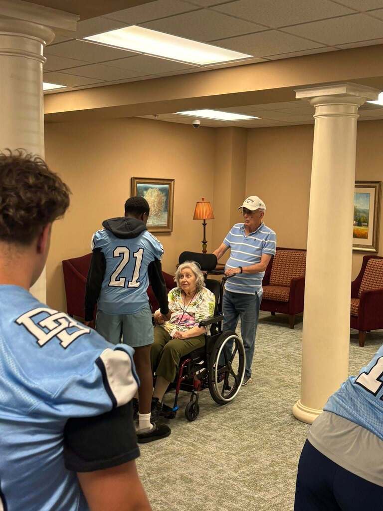 Members of the Boone football team shaking hands with residents of Keystone Villas