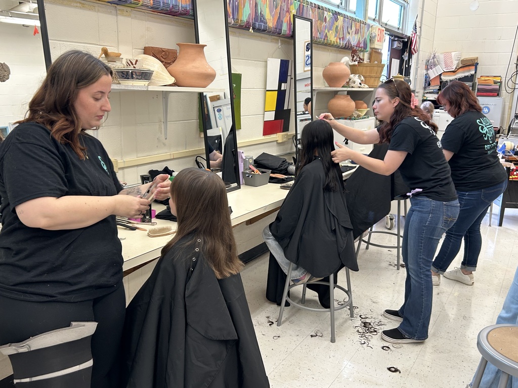 Picture of three stylists from Salon Aspire cutting students' hair.