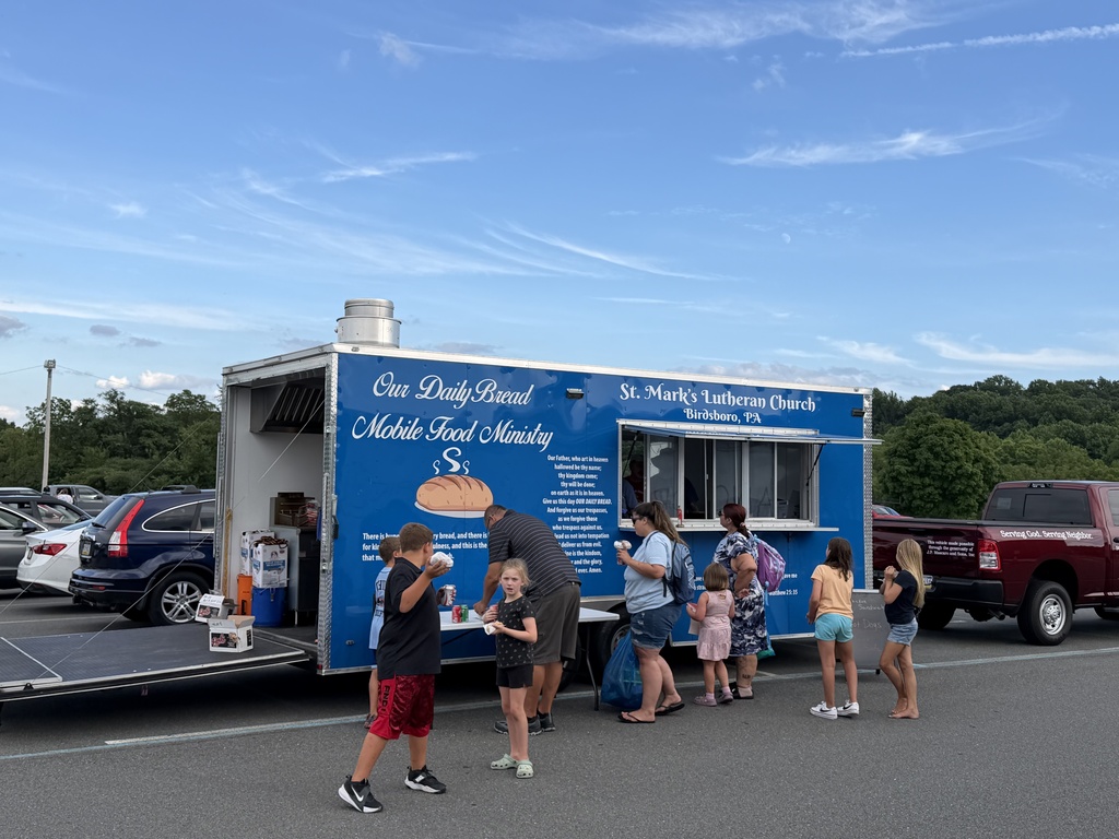 Picture of St. Mark's Lutheran Church food truck with people standing outside with food.