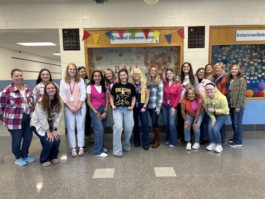 18 Intermediate Center staff members wearing their flannel shirts, pink, yellow and white clothes in memory of Dolly Parton.