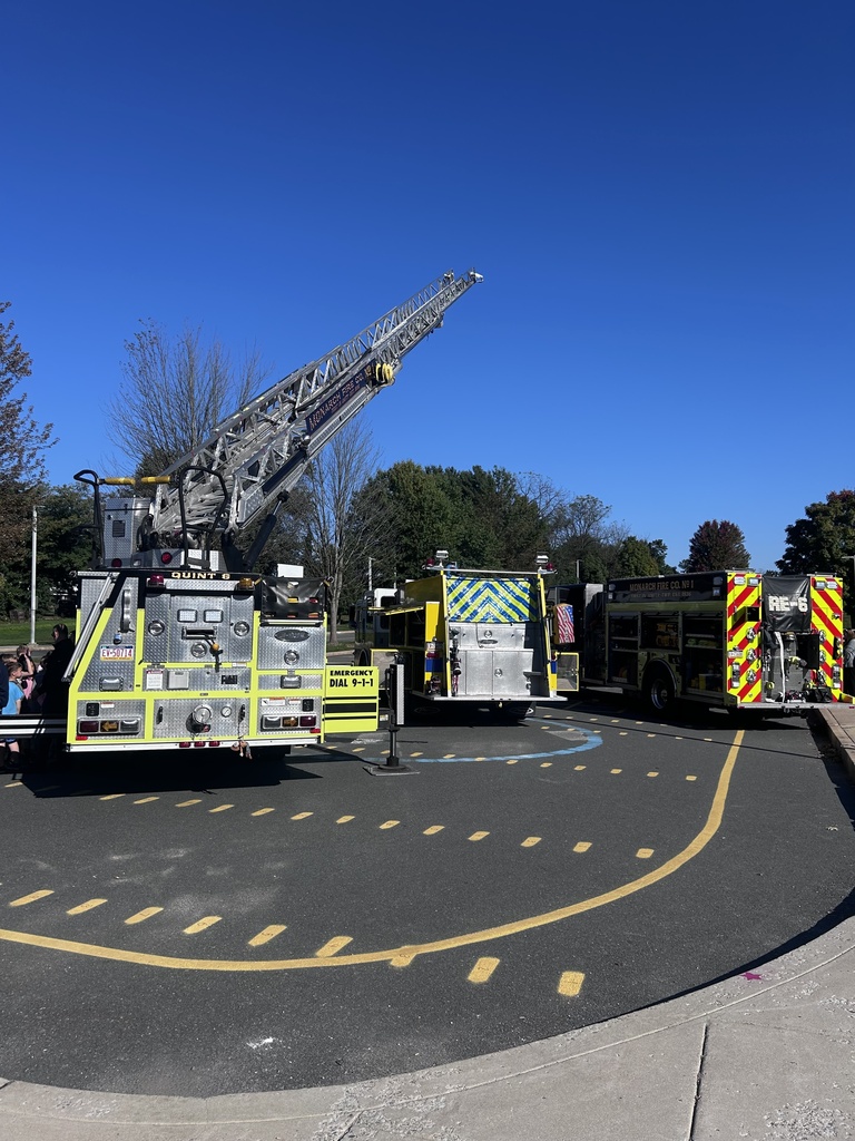 Photo of three fire trucks parked on the school playground for students to view.
