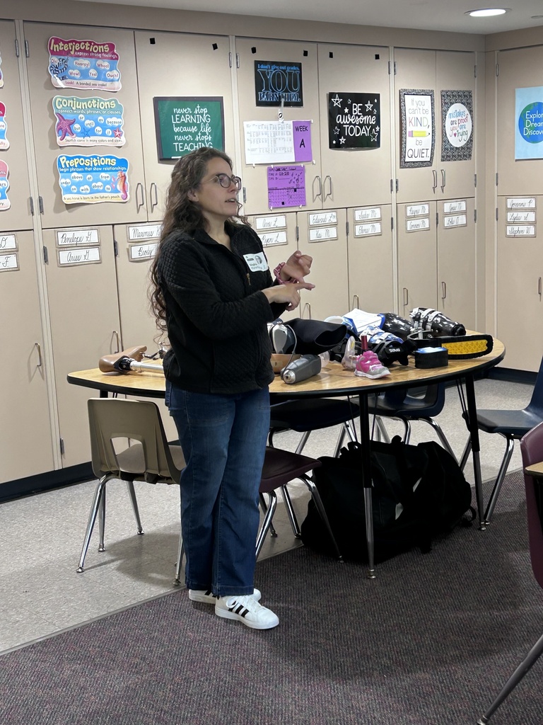 A presenter standing next to table with prostheses and orthoses on display.