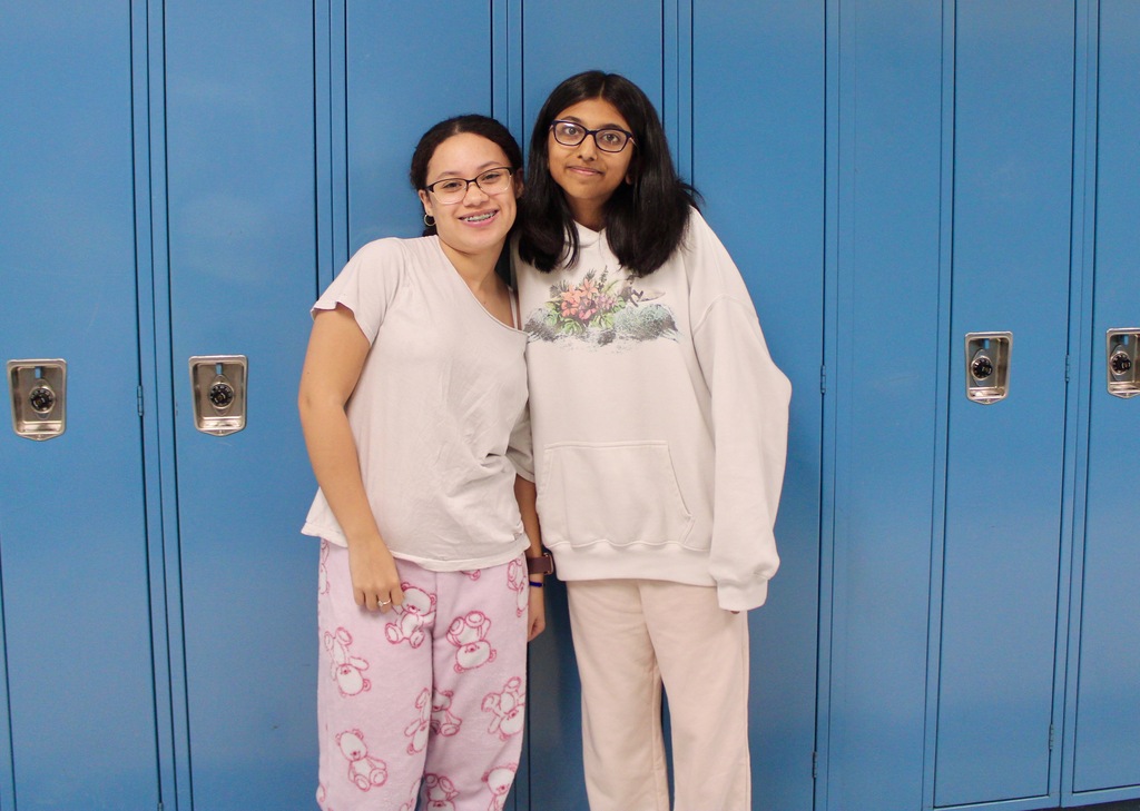 Students standing in front of lockers wearing pajamas.