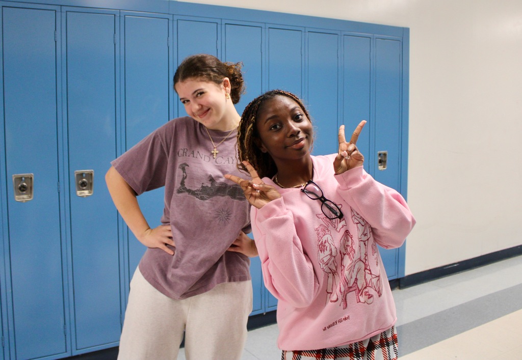 Students standing in front of lockers wearing pajamas.