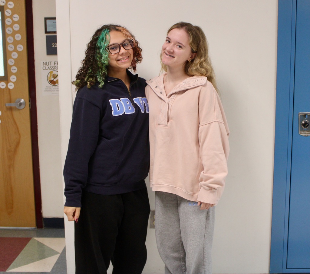 Students standing in front of lockers wearing pajamas.