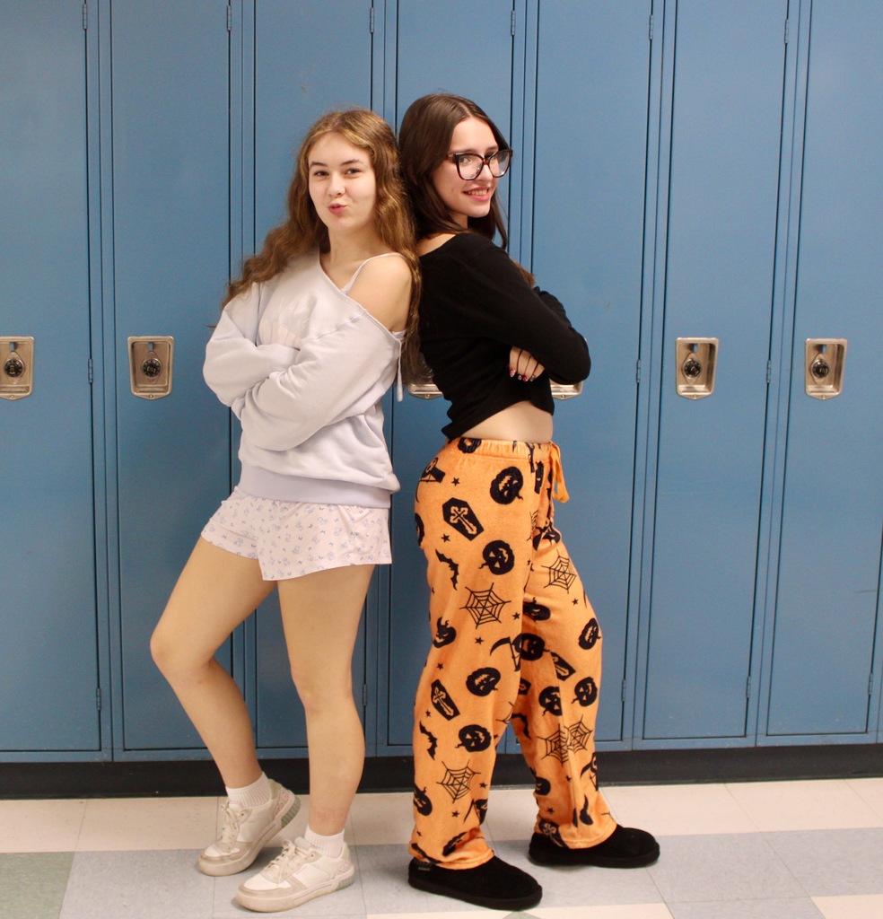 Students standing in front of lockers wearing pajamas.