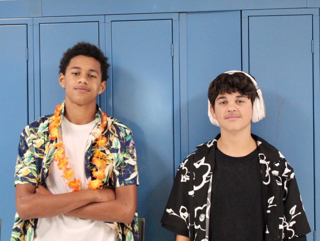 Two students show off their homecoming spirit by wearing Hawaiian shirts and one is wearing a lei.