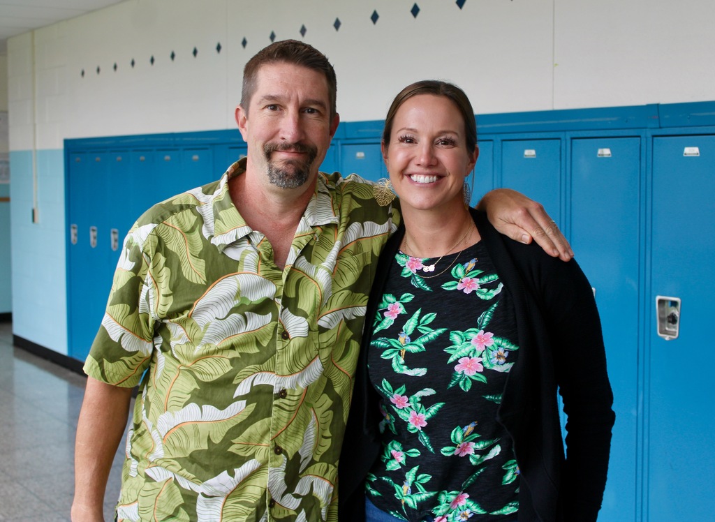 Two teachers show off their Hawaiian shirts.