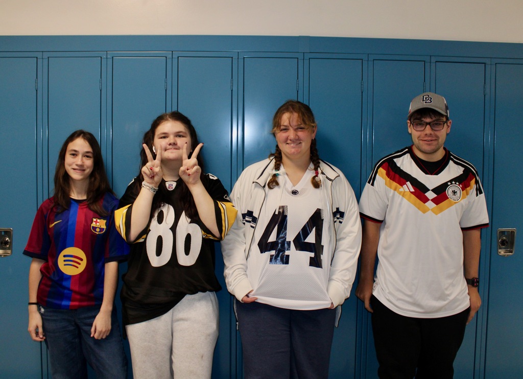 Four students wearing various jerseys - soccer, Steelers, etc. 