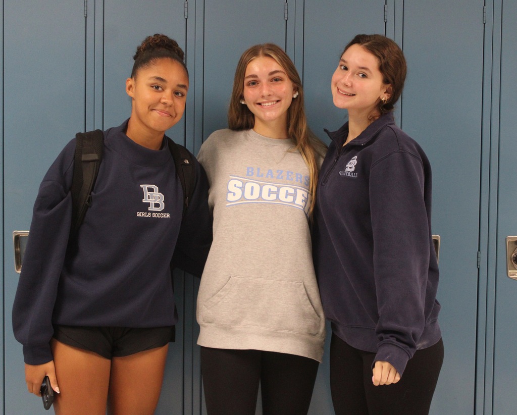 Students showing off their Blazers soccer and basketball gear
