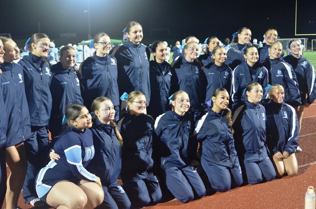 Cheerleaders wearing DB track suits pose for a photo.