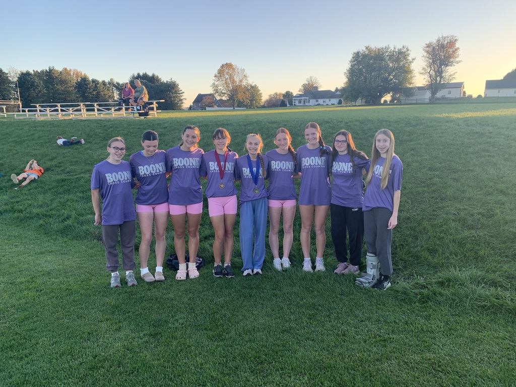 Boone Cross Country Team standing next to a grassy hill