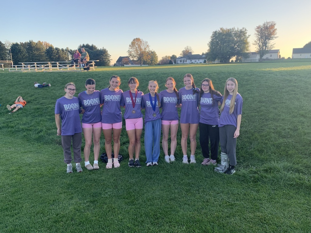 Boone Cross Country Team standing next to a grassy hill