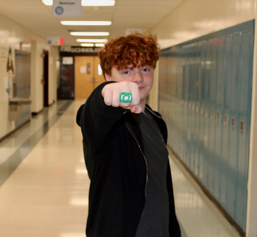 A student poses with his fist outstretched to the camera showing his Green Lantern ring.